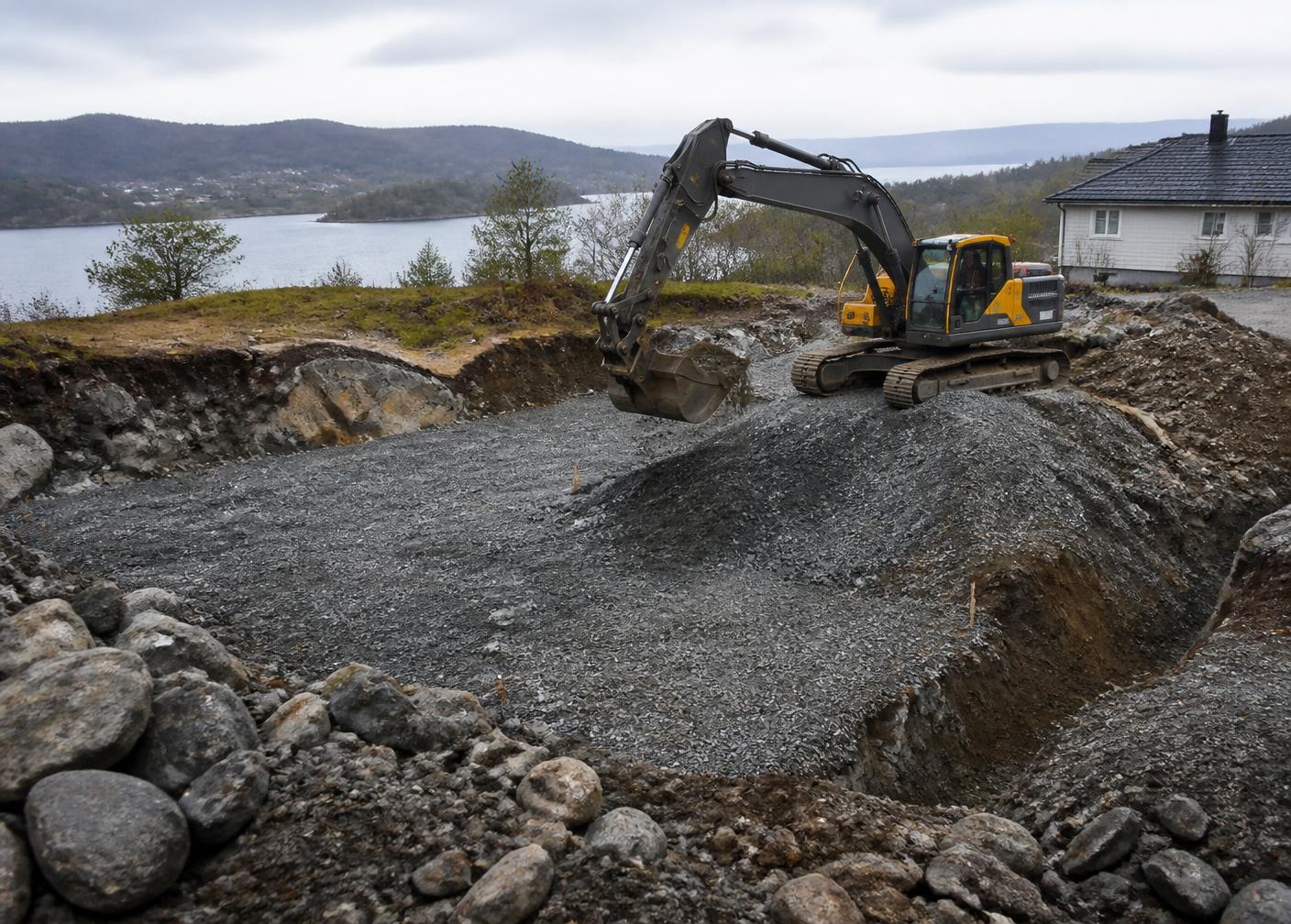 Illustrasjonsbilde: gravemaskin i arbeid med utgraving og masseflytting på en norsk tomt.